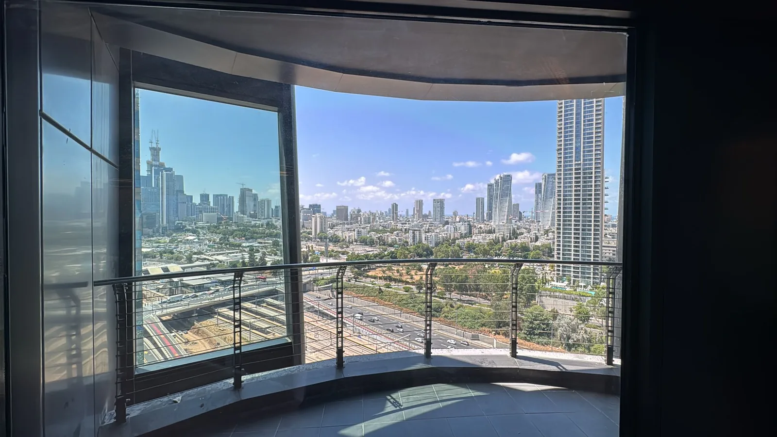 מרפסת מעוקלת עם נוף פנורמי לתל אביב ולנתיבי איילון